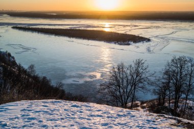 Panoramik Samara şehri yakınlarındaki tepe üzerinden günbatımı sırasında kışın donmuş Volga Nehri üzerinde