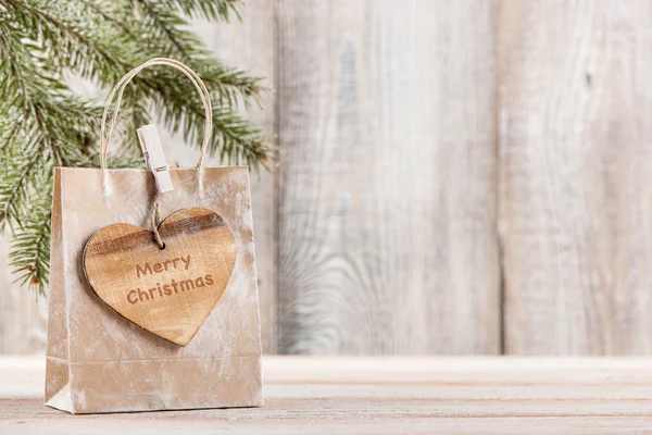 木製のハート形のタグとメリー クリスマス ギフト バッグします。 — ストック写真
