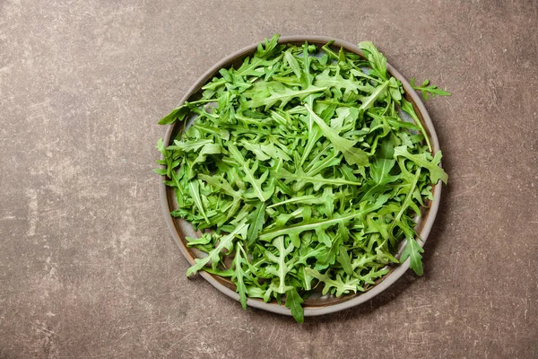 Fresh rucola leaves on ceramic plate