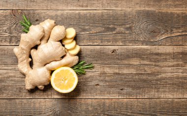 Tahta zemin üzerinde zencefil kökü ve taze limon.