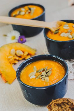 Ahşap arka plan üzerinde kabak çekirdeği ile kavrulmuş balkabağı çorbası.