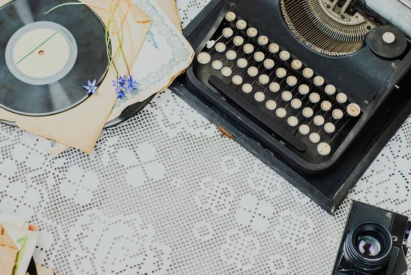 Vintage office desk with typewriter, stack of vinyl and camera on tablecloth — Stock Photo, Image