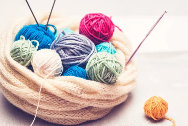 renkli yün topları ve örgü iğneleri ahşap arka plan üzerinde