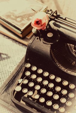 Tablo pembe Gül, eski kitapları ile antika daktilo.