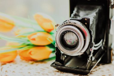 Vintage fotoğraf makinesi ile güzel buket çiçek örgü masa örtüsü üzerinde. Eski Vintage natürmort kavramı.