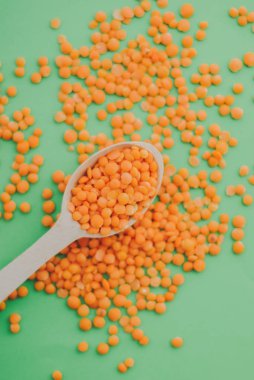 Red lentil in wooden spoon