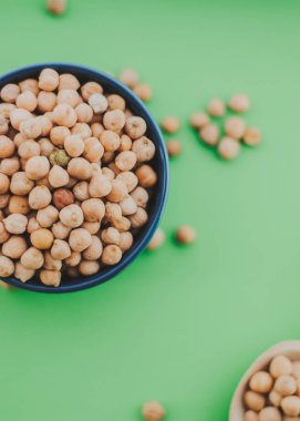 kase yeşil zemin, lezzetli vejetaryen yemekleri üzerine tahta kaşıkla altın nohut