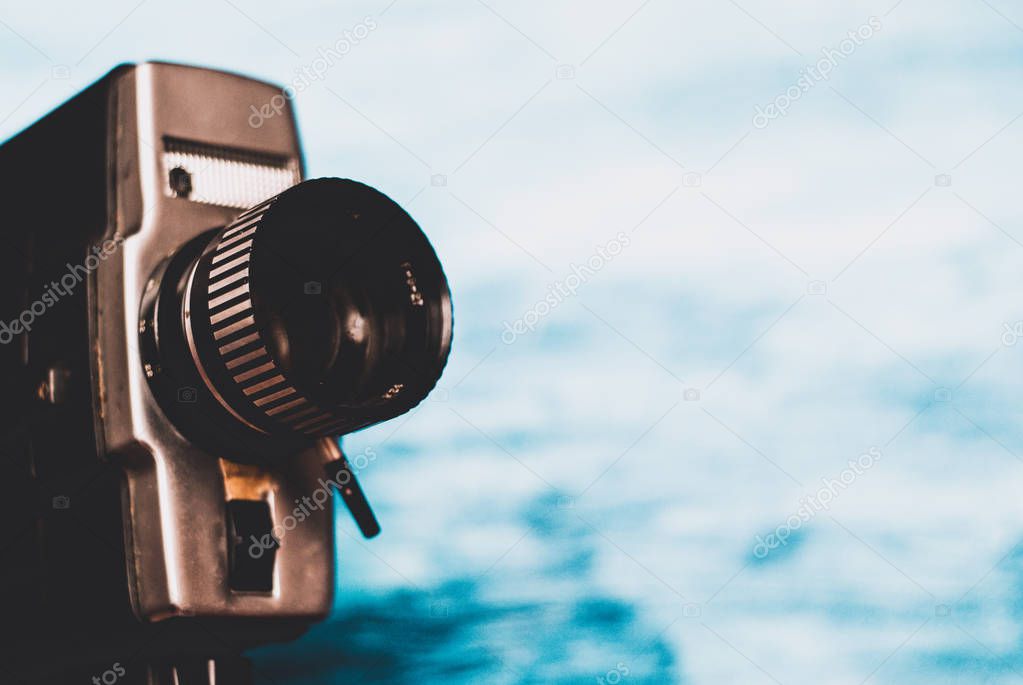 Vintage movie camera on blue background