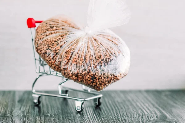 小超市推车特写小包干荞麦。消费者对验尸官恐慌的概念 — 图库照片