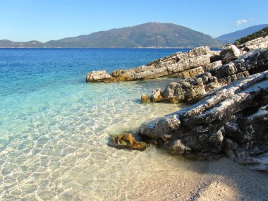 Kefalonia şeffaf denizde Itaca ada arka planda, Yunanistan ile beyaz bir plaj
