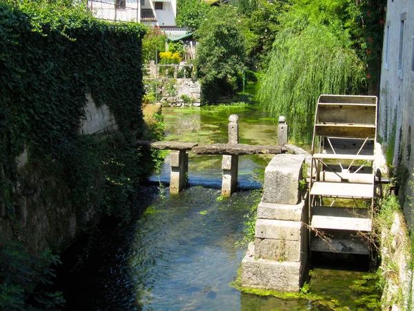 Um moinho de água em um pequeno rio verde, Strassoldo, Itália — Fotografia de Stock