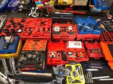 Bir pazar yerinde bir arabayı tamir etmek için birçok mekanik renkli alet kutusu.