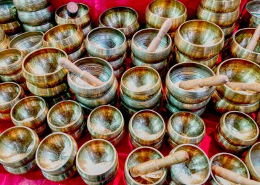 Kırmızı arka planda ahşap vuruculu birçok Tibet şarkı kasesi var. Hdr etkisi.