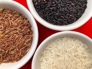 Üç çeşit pirinç: kahverengi kırmızı bütün, beyaz Hint Basmati ve siyah İtalyan Venere (Venüs).