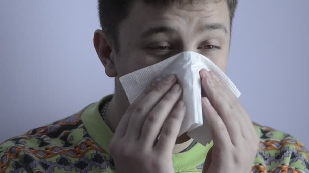 Young man with cold blowing her nose — Stock Video