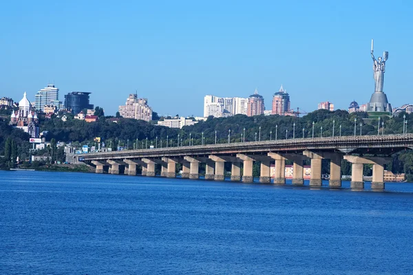 Paisaje urbano. Ciudad en una mañana soleada. Puente conecta las dos partes de Kiev — Foto de Stock