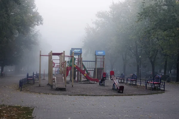 Brouillard dense dans la ville. Tôt le matin à Kiev. Aire de jeux vide attend les petits enfants — Photo