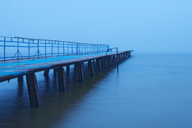 Göl sisli sabahı. Eski terk edilmiş iskele sis gider