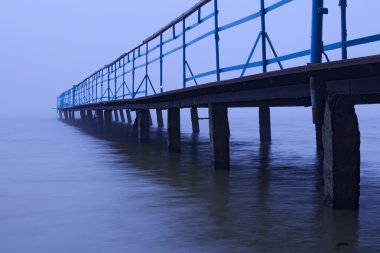 Göl sisli sabahı. Eski terk edilmiş iskele sis gider