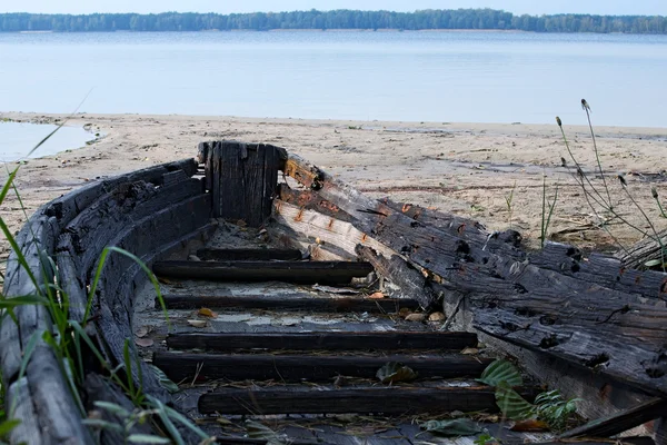 Un viejo bote de madera abandonado en el lago. primer plano de la nariz del barco — Foto de Stock