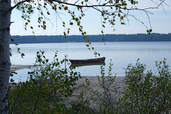 Krásná dřevěná loď kotvící u břehu jezera — Stock fotografie