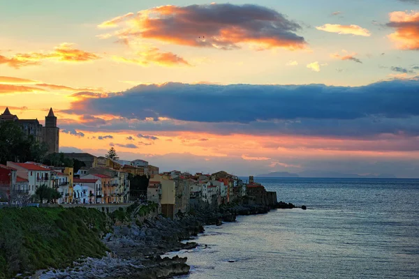 Cores incríveis do céu durante o pôr do sol. Casas coloridas em uma costa rochosa perto do mar. Cefalu. Sicília. Itália — Fotografia de Stock