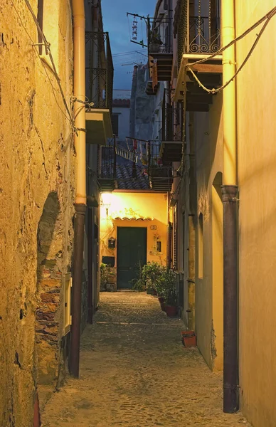 Una calle estrecha se extiende hasta las puertas delanteras de una bonita casa. Cefalu. Sicilia. Italia — Foto de Stock