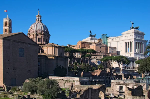 ROME, ITALY - JANUARY 6, 2017: Ancient monuments, ruins and columns in Roman Forum. The Altare della Patria also known as the Monumento Nazionale a Vittorio Emanuele II or "Il Vittoriano". Rome, Italy — Stock Photo, Image