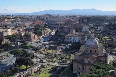  Roma manzarası çatılarının üzerinden anıt, Vittorio Emanuele II, Piazza Venezia görüntüleyin. Roma Forumu ile tarihi yapıların kalıntıları. Colosseum içinde belgili tanımlık geçmiş. Kış sabah görünümü