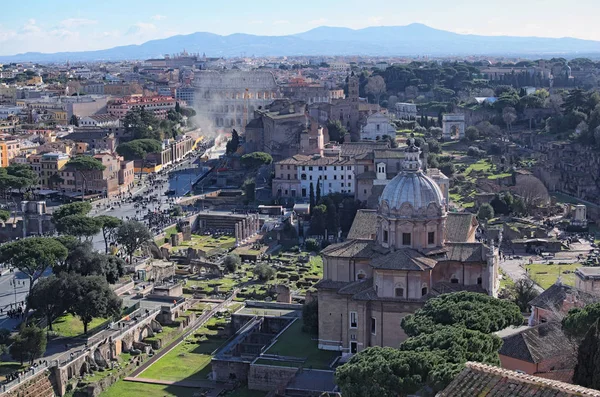 Vista para os telhados de Roma skyline do Monumento de Vittorio Emanuele II na Piazza Venezia. Fórum de Roma com ruínas de edifícios históricos. Coliseu ao fundo. Vista da manhã de inverno — Fotografia de Stock