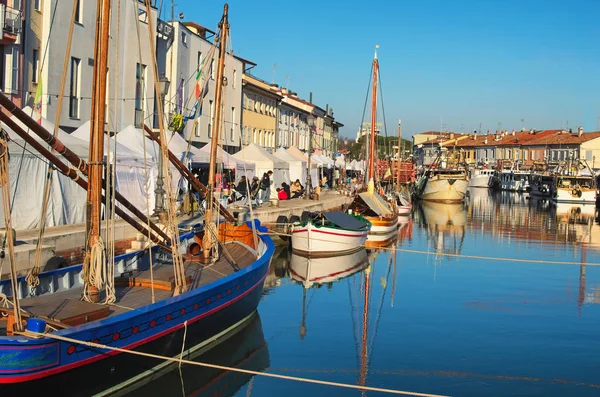 CESENATICO, ITÁLIA: 01 JANEIRO 2017- Feira de Natal quiosques no aterro do canal portuário com os barcos de pesca típicos do Mar Adriático — Fotografia de Stock