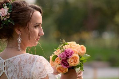 İnanılmaz derecede güzel gelin gül buketi ile. Nişanlısı romantik aksesuar. Uzun saçlı kız gelinlik