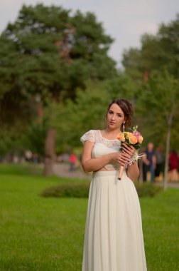 İnanılmaz derecede güzel gelin gül buketi ile. Nişanlısı romantik aksesuar. Uzun saçlı kız gelinlik