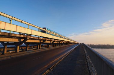 Metro tren Köprüsü hareketli. Kiev, Ukrayna Dnipro Nehri'nin üzerinde Metro (metro) köprüye görüntüleyin. Kış sabah güneş doğarken