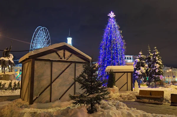 Voorbereidingen voor de kerstvakantie en het nieuwe jaar. Installatie van een reuzenrad op de Christmas Fair op het plein van het Contract. Prachtig versierde kerstboom. Weergave van de avond — Stockfoto