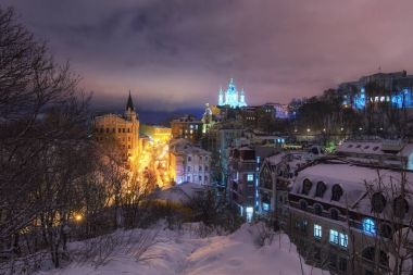 Amazing view of the Andreevsky Descent. The most famous building at this street are Richard's Castle and St. Andrew's Church in winter evening clipart