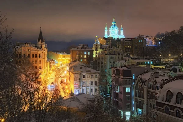 Vista del descenso de Andreevsky y la iglesia de San Andrés en el fondo en la noche de invierno. La calle, a menudo anunciada por los guías turísticos y operadores como "Montmartre de Kiev", es una de las principales atracciones turísticas — Foto de Stock