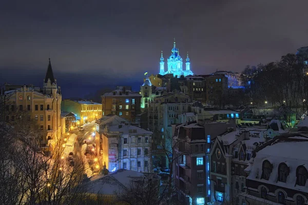 Increíble vista del descenso de Andreevsky. Los edificios más bellos de esta calle son el Castillo de Richard (a la izquierda) y la Iglesia de San Andrés (al fondo) en la noche de invierno. — Foto de Stock