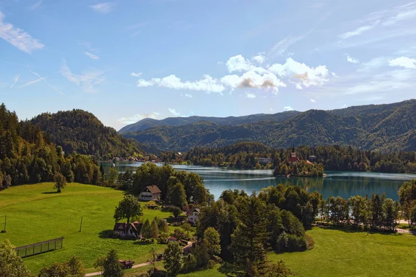 Landschaftspanorama aus der Luft mit dem See und der Marienkirche auf einer kleinen Insel. erstaunliche Berge im Hintergrund. sonniger Herbsttag. Slowenien ausgeblutet — Stockfoto