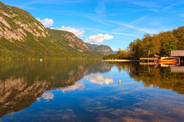 Bohinj Gölü 'nün panoramik manzarası. Turkuaz suya yansıyan manzaralı dağ sırasının hayret verici doğa manzarası. Bohinj Gölü, Triglav Ulusal Parkı, Slovenya. Manzara ve doğa kavramı