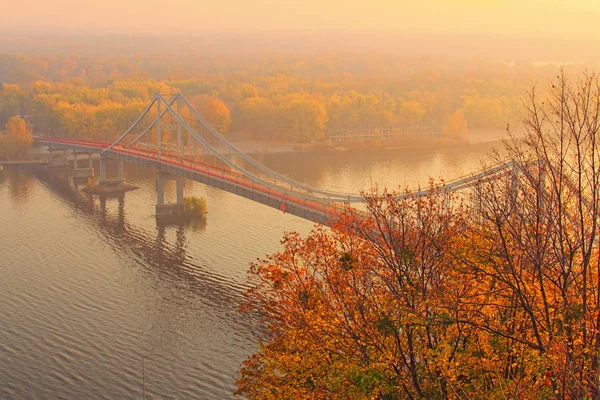 유명 한 드니 프강의 아름다운 가을 풍경이다. 보행자다리는 물에 반사되었습니다. 자연의 풍경 과 가을의 색들 이 배경에 있습니다. 우크라이나, 키프 — 스톡 사진