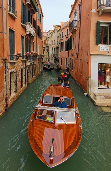 Veneza, Itália-28 de setembro de 2019: Vista panorâmica clássica do barco de táxi de madeira no canal estreito da cidade. O transporte mais rápido e conveniente em Veneza. Várias gôndolas em segundo plano — Fotografia de Stock