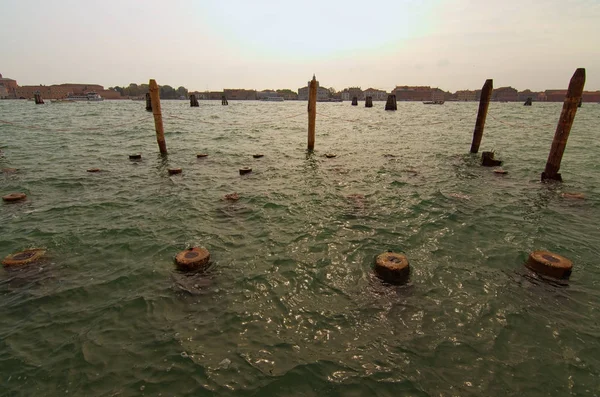Salzwasser und Wetter zerstörten die Holzpfähle. Um einen Unfall zu vermeiden, wurde ein Zaun mit einer Metallkette errichtet. Herbstlandschaft. Venezianische Lagune, Venedig, Italien — Stockfoto