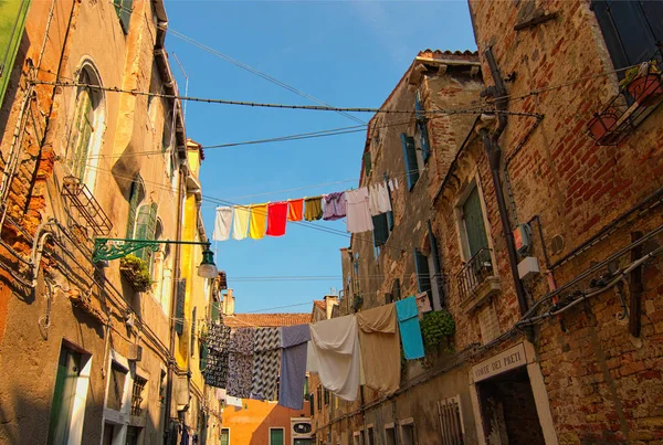 Venecia, Italia-28 de septiembre de 2019: Esquina típica de la ciudad con antiguos edificios coloridos en la parte no turística de Venecia. Secar la ropa en una línea de ropa al aire libre en el soleado día de otoño — Foto de Stock