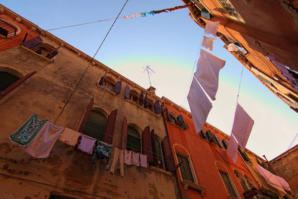 Типичная улица с древними красочными зданиями в нетуристической части Венеции. Сушка одежды на линии одежды на открытом воздухе в солнечный осенний день. Романтическая и мирная сцена. Вениче, Италия — стоковое фото