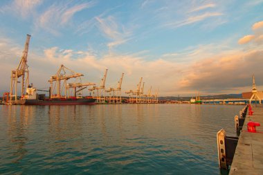 Koper 'in uluslararası kargo limanının geniş açılı manzarası. Boş konteyner gemisi konteynırların yüklenmesini bekliyor. İthalat, ihracat ve iş lojistiği. Uluslararası su taşımacılığı. Slovenya