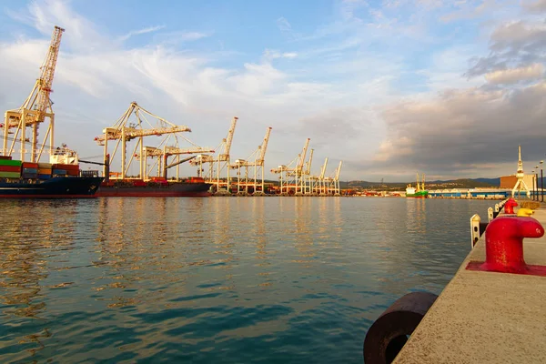 Wide angle view of big harbor with cranes. Container ship loading by containers. Import, export and business logistic. International water transport. Harbor of Koper, Slovenia