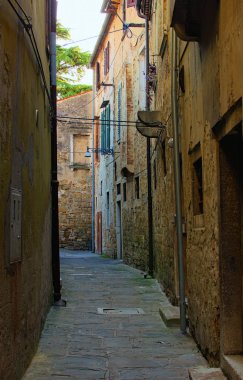 Koper şehrinin boş dar sokağının manzarası. Eski şehir manzarası, eski ev duvarları, taş kaldırımlar. Koper, Slovenya