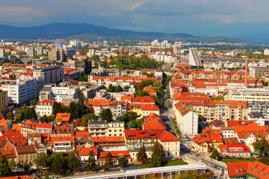 Ljubljana, Slovenya-29 Eylül 2019: Güneşli bir sonbahar gününde şehrin veya eski bölümünün resimli hava görüntüsü. Kırmızı kiremit çatılı antik binalar, arka planda dağ sıraları. Titrek gökyüzü