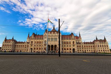 Scenic landscape view of The Hungarian Parliament Building. Square in front of the building with many tourists. It is notable landmark of Hungary and a popular tourist destination in Budapest